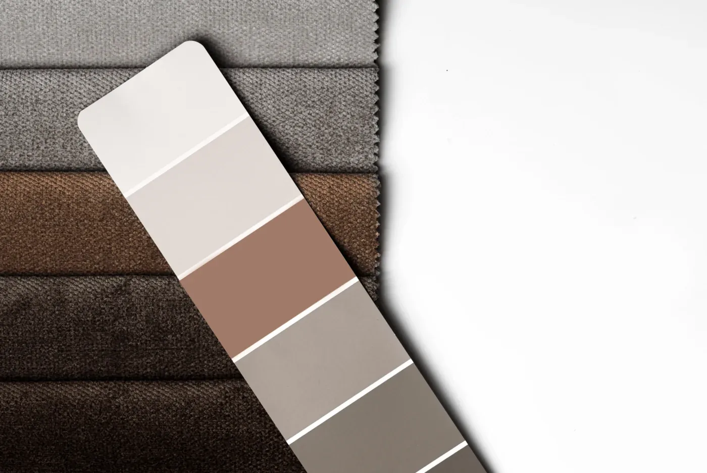Cellular shade fabric swatches and a color sample card in greys and warm browns