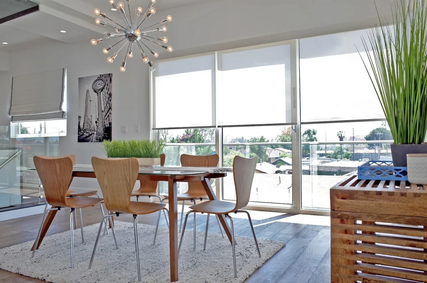 Side-by-side motorized roller shades with white cassette headrails on a sliding door