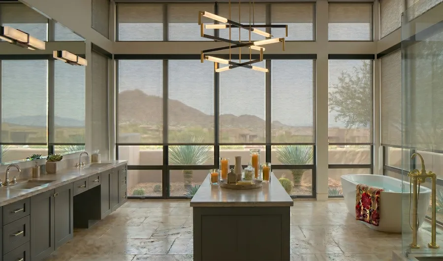 Floor-to-ceiling solar shades softening the mountain view in a luxury primary bathroom