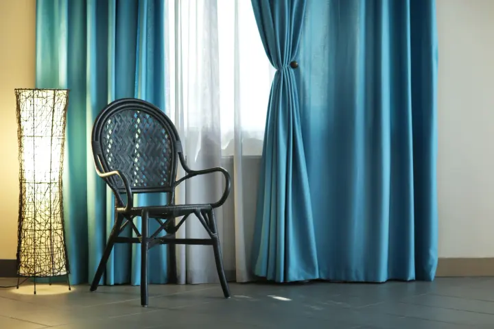 Blue and white drapery behind a black chair and light