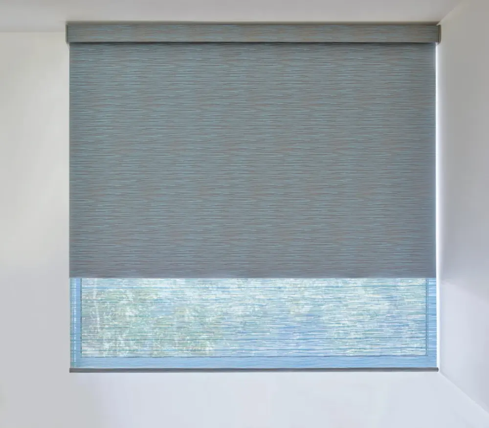 Close-up view of grey roller window shades against a light grey wall
