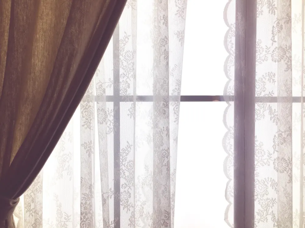 Closeup of a darker panel pulled back over white sheer panels