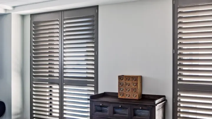 Room with white interior and gray half-closed shutters