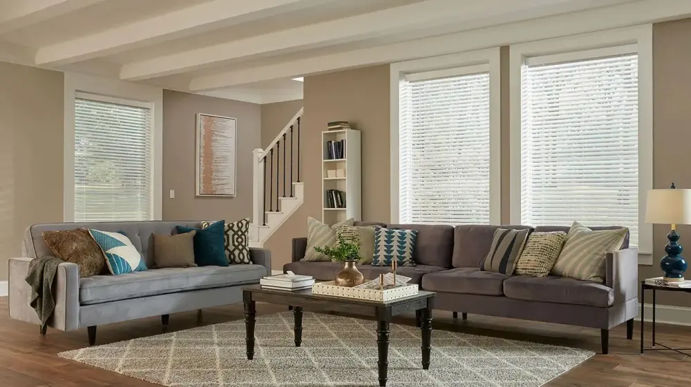 A living room with motorized blinds on all the windows.