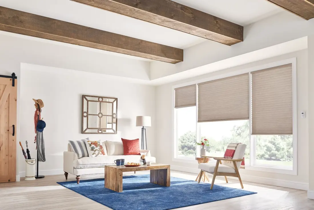 Motorized shades at three different levels on windows in a sitting room.
