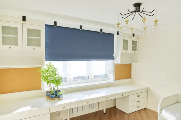 A child’s room with a blue window shade