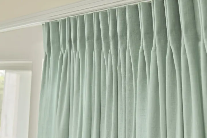 Close-up of pleats on a green drapery.