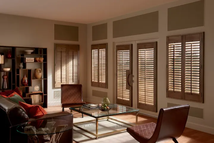 A dual kitchen and dining room with multiple windows covered with sleek white blinds.