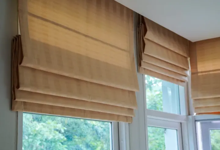 Light brown/gold roman shades over windows in Las Vegas | Southwest Blinds and Shutters
