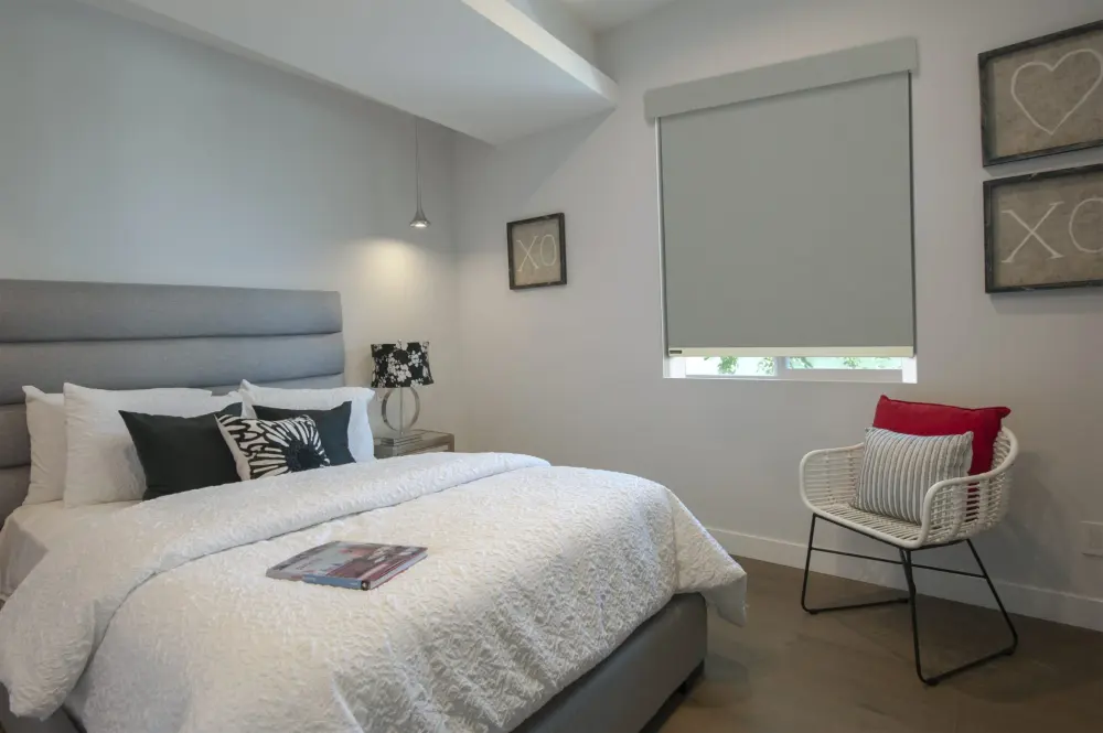 Excellent gray roller shades provide room-darkening coverage and privacy in a modern Carefree, AZ bedroom.