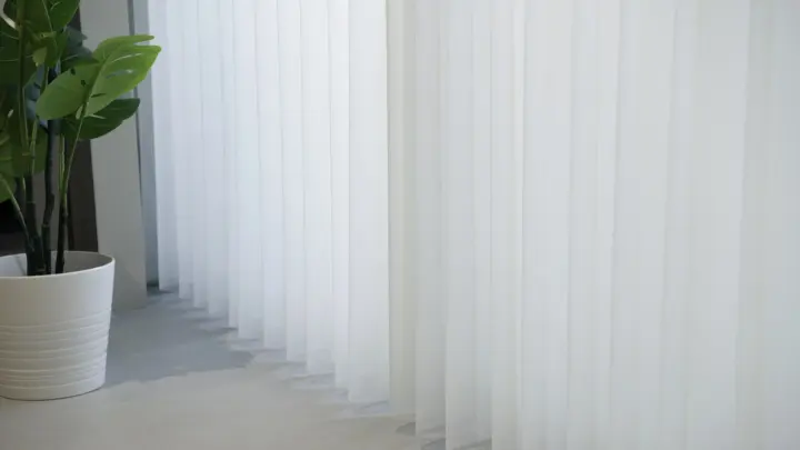 Close-up of long white drapes that go to the floor