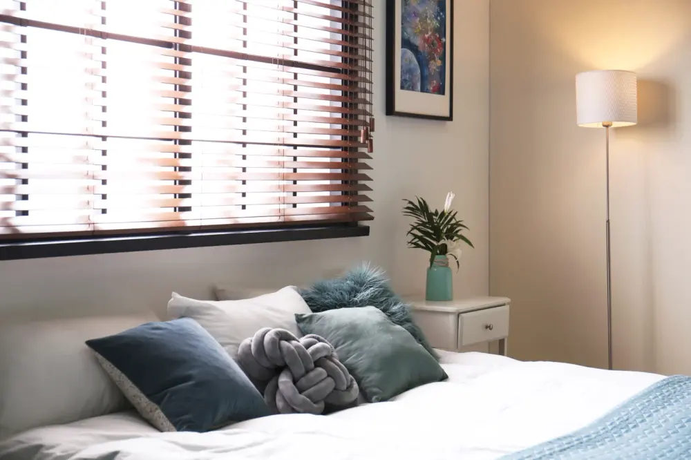Wood blinds in bedroom of Whitney home installed by Southwest Blinds & Shutters