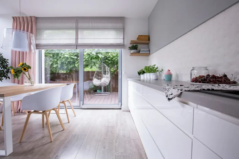 Charming window shades in a dining room leading to a patio