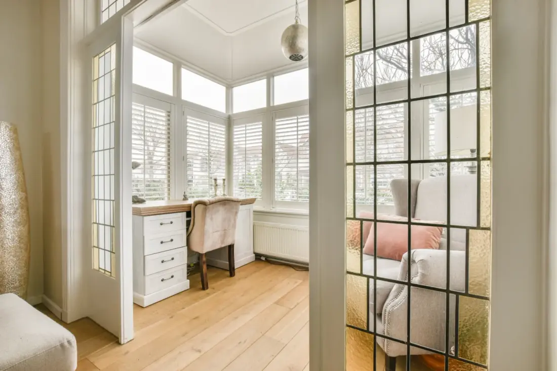 A Sun Room With A Bed And A Desk With