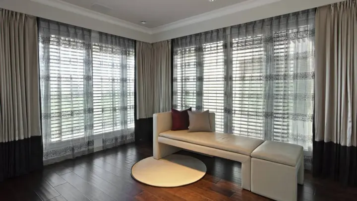 Gorgeous living room with hardwood floors, beige furniture, and three layer window treatments