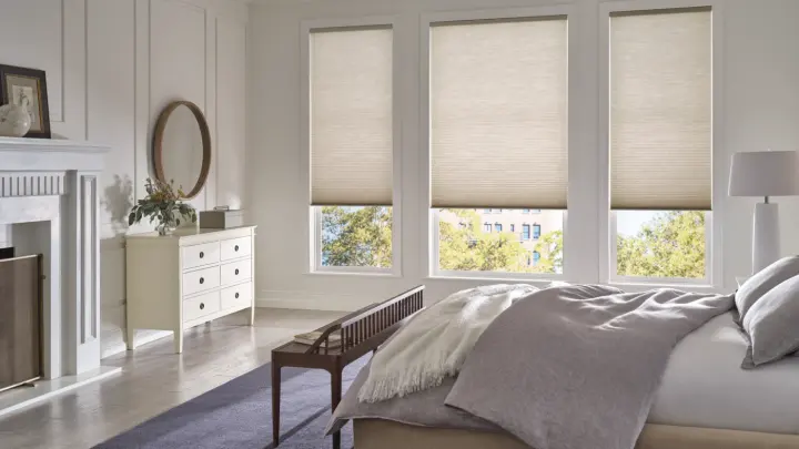 Home bedroom with three small windows with cellular shades on them