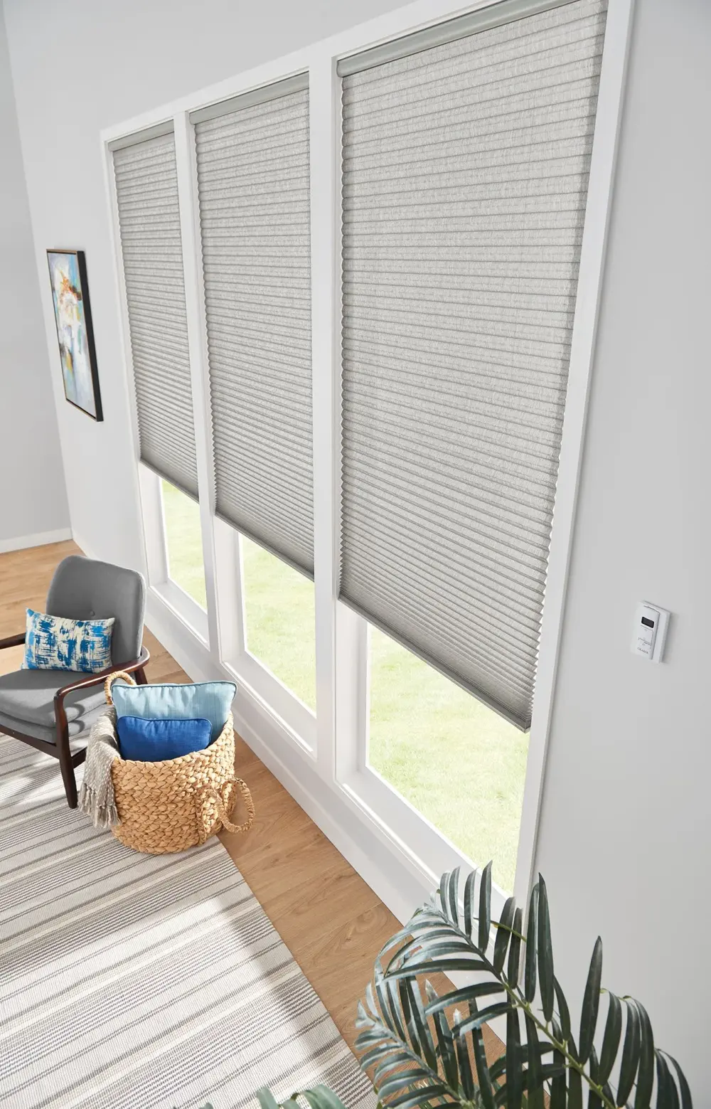 Three tall windows with custom window shades in gray.