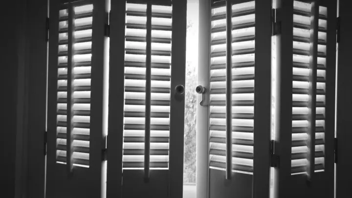 Closeup of shutters partially closed over a window
