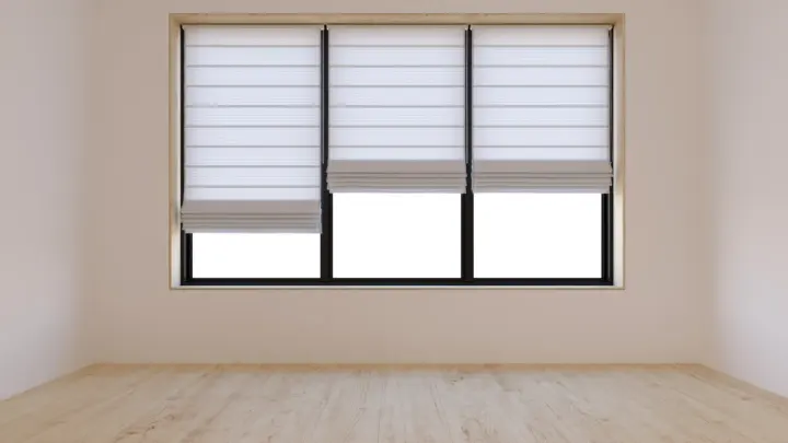 A room with three windows with shades, each at a different height