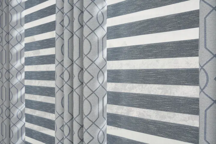 Close-up of gray sheer shades layered with custom drapery.