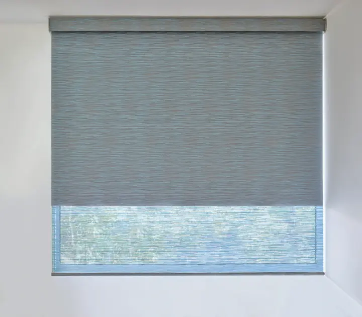 A roller shade is fully closed in a cozy bedroom, blocking out the morning sun.