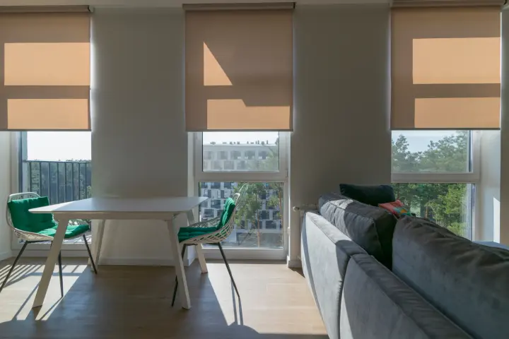 Three tan motorized shades in a modern apartment