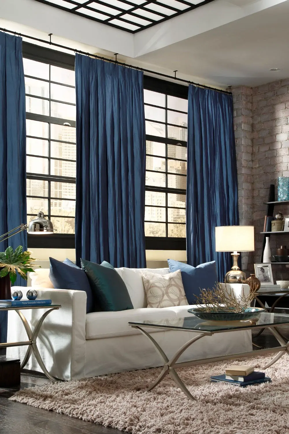 Close-up of a window drapery with gray flowers layered over gray shades.