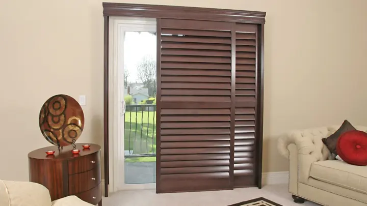 Window with newly installed wooden shutters on it