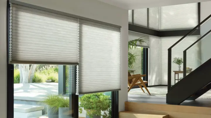 Modern home interior with white motorize pleated shades on large windows