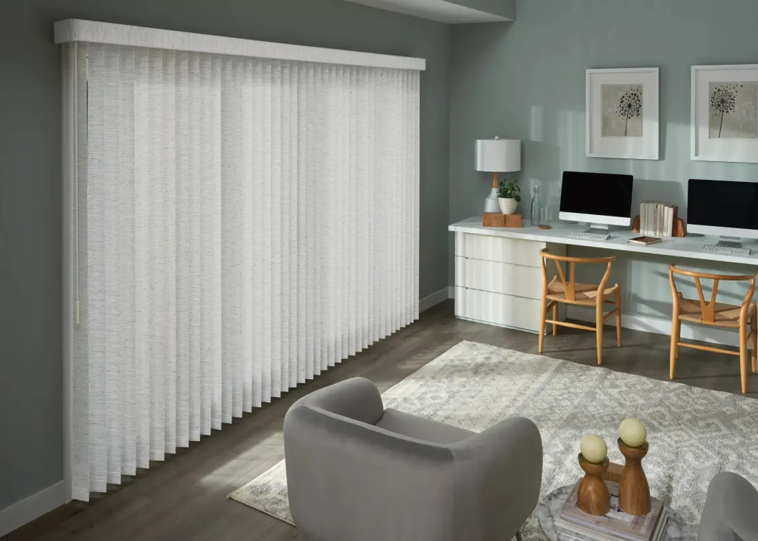 An image of a modern home office featuring custom vertical blinds over a large sliding glass door