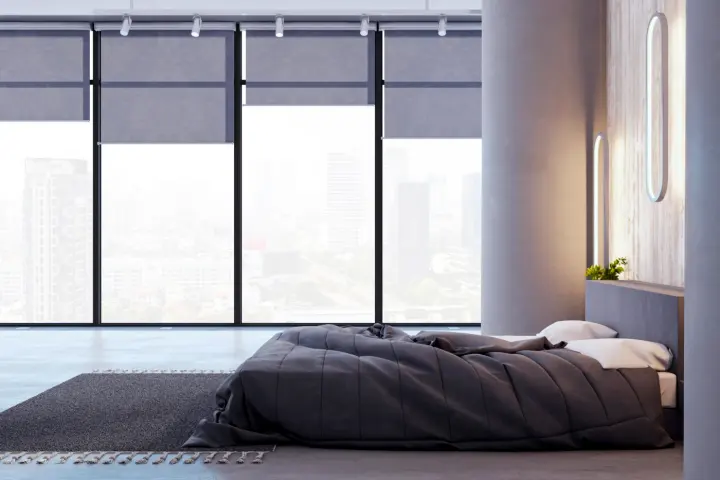 A bedroom with a wall of windows with motorized shades open at varying heights