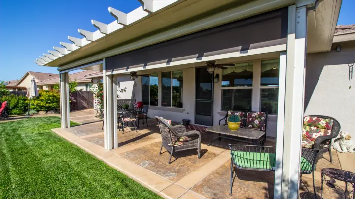 A patio seating area with a pergola with patio shades