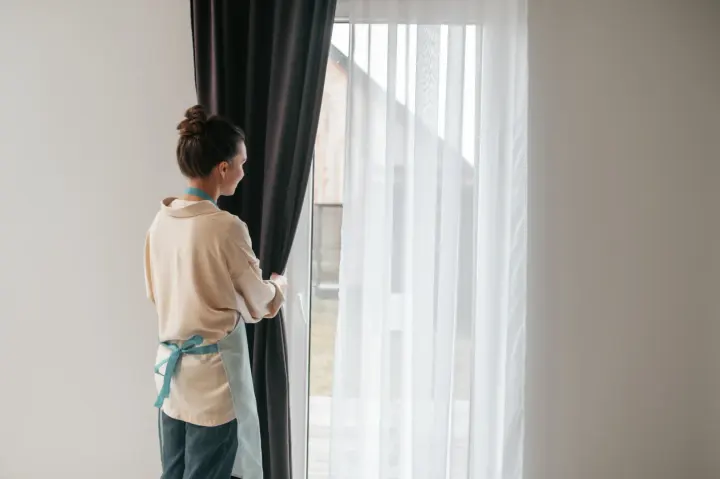 Woman standing in front of sheer window coverings in Las Vegas | Southwest Blinds and Shutters