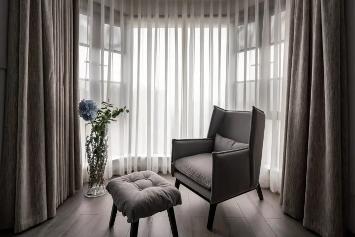 Window covered with sheer drapery and gray drapes