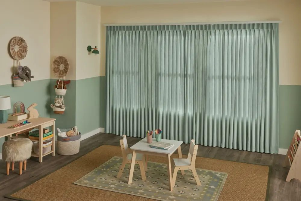 A room with green and beige painted walls with full-length green drapery closed.