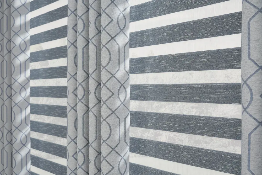 Close-up of gray sheer shades with gray-patterned curtains.