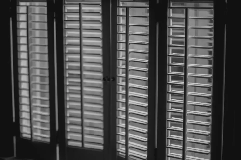 Stylish dark plantation shutters over living room windows in Peoria, AZ.