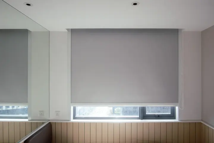 Gray motorized roller shades over a window