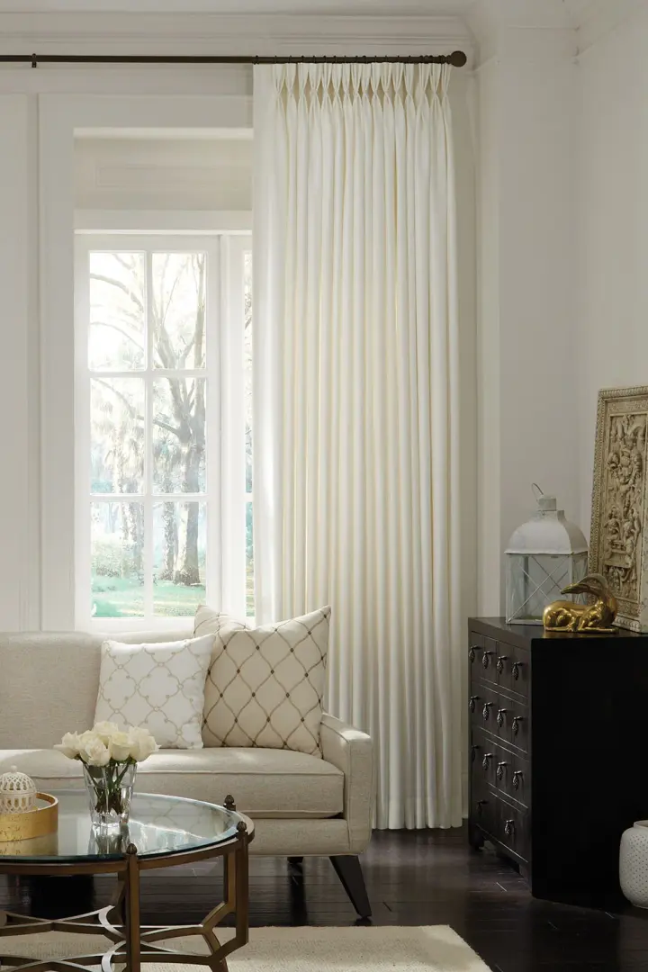 Home with large drapery tied up with window outlooking a beautiful snowy day