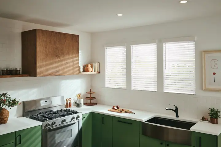 Small room with bed, nightstand, and painting on the wall with large vertical white blinds on the window | Southwest Blinds