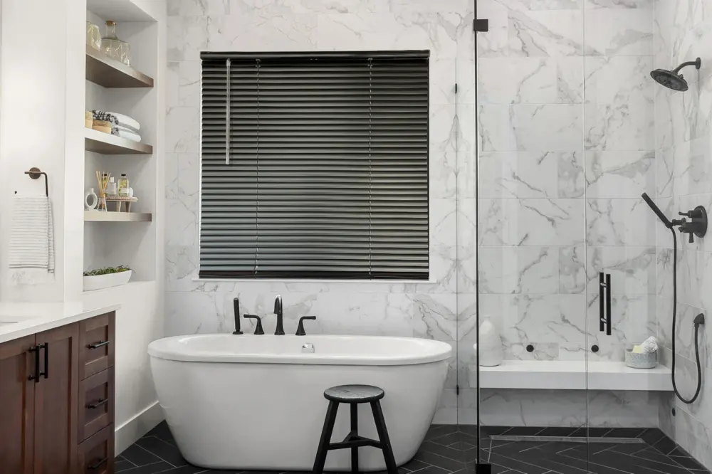 Aluminum blinds in a window above tub in bathroom