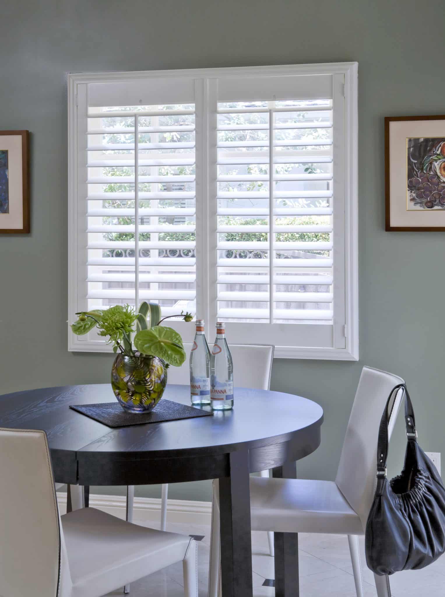White Window Shutters On Bay Window In Front Of Sitting Area In The Home