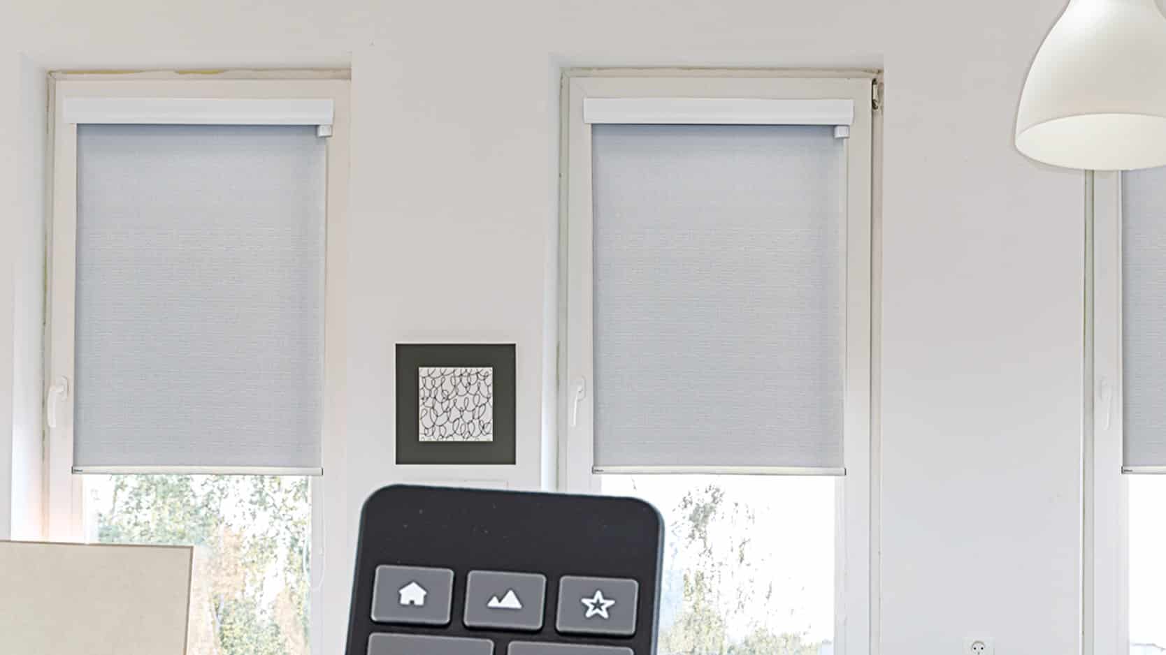 Two Motorized Off-White Window Shades Installed On Small Windows